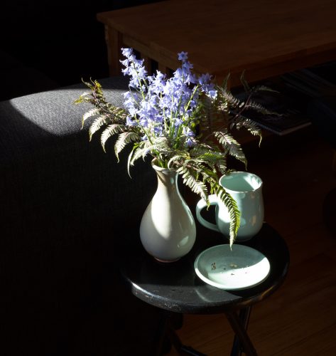 Vase with flowers and coffee cup